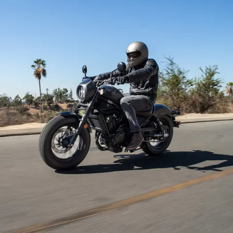 Honda CMX500 Rebel met mannelijke rijder op de weg. 