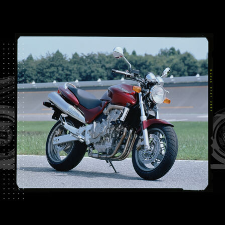 Driekwart vooraanzicht Honda Hornet geparkeerd op een circuit.