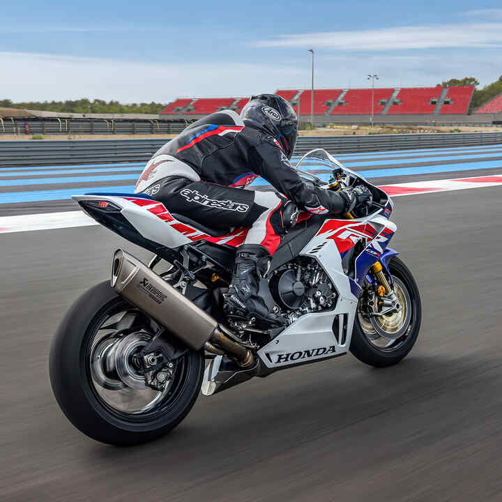 Driekwart achteraanzicht van de Honda CBR1000RR-R-Fireblade met rijder op het circuit